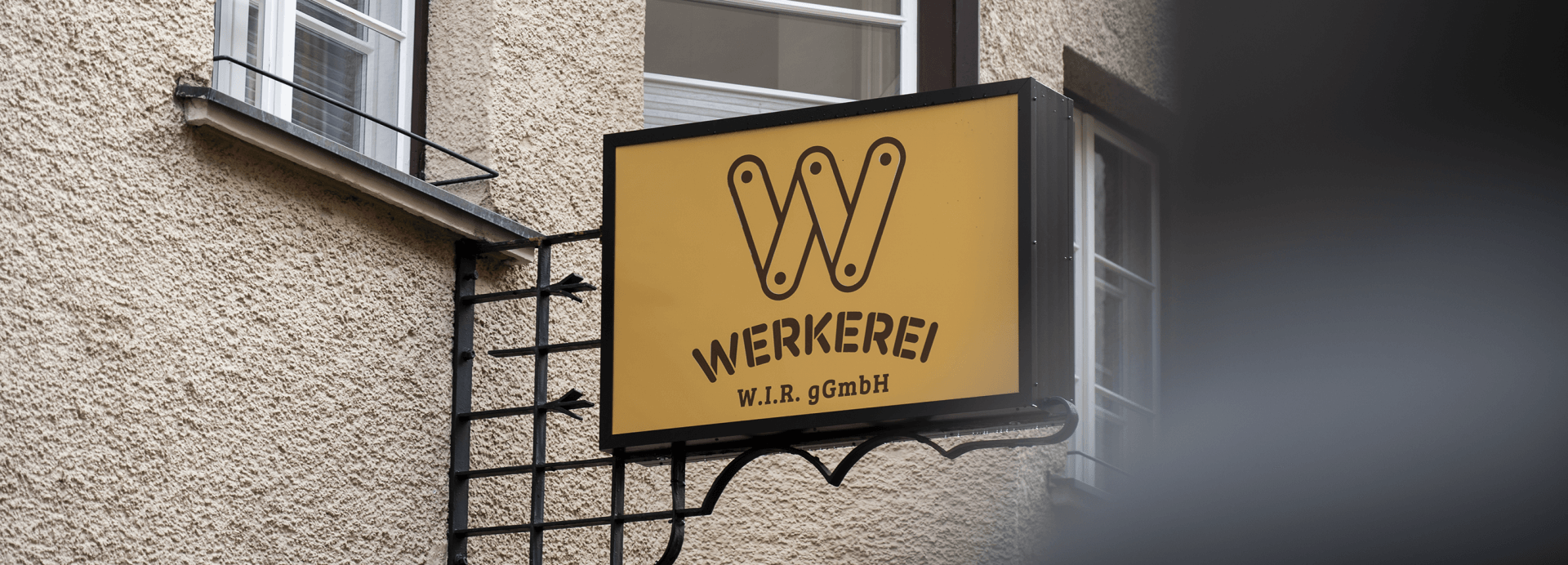 W.I.R Logo auf montiertem Schild an Werkerei-Wand in Hall in Tirol